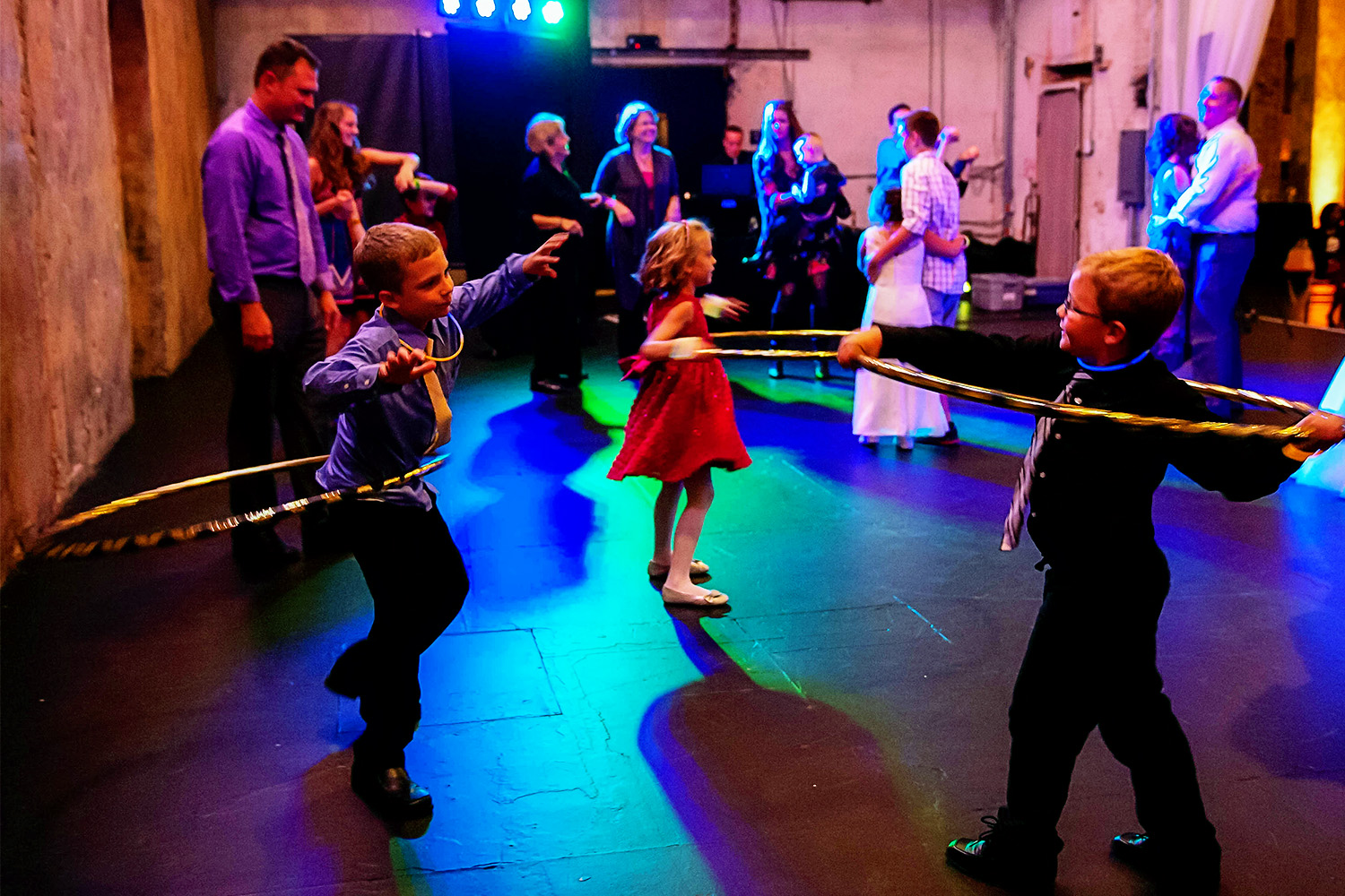 kids dancing with hula hoops on the dance floor at a wedding
