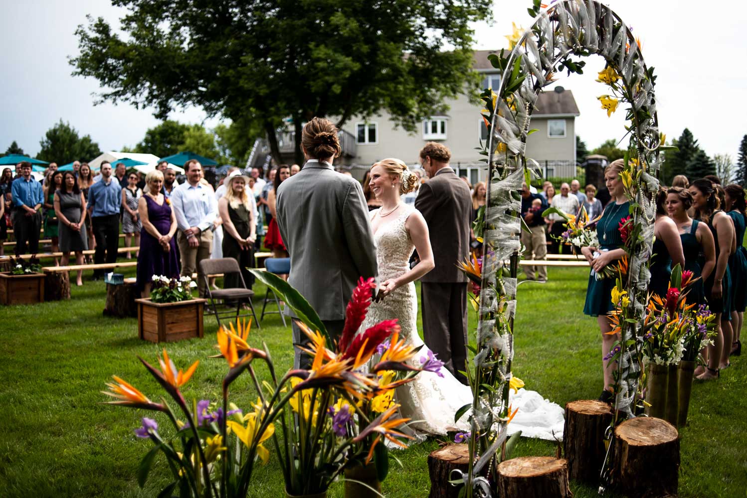 bride and groom holding hands during their summer backyard wedding ceremony
