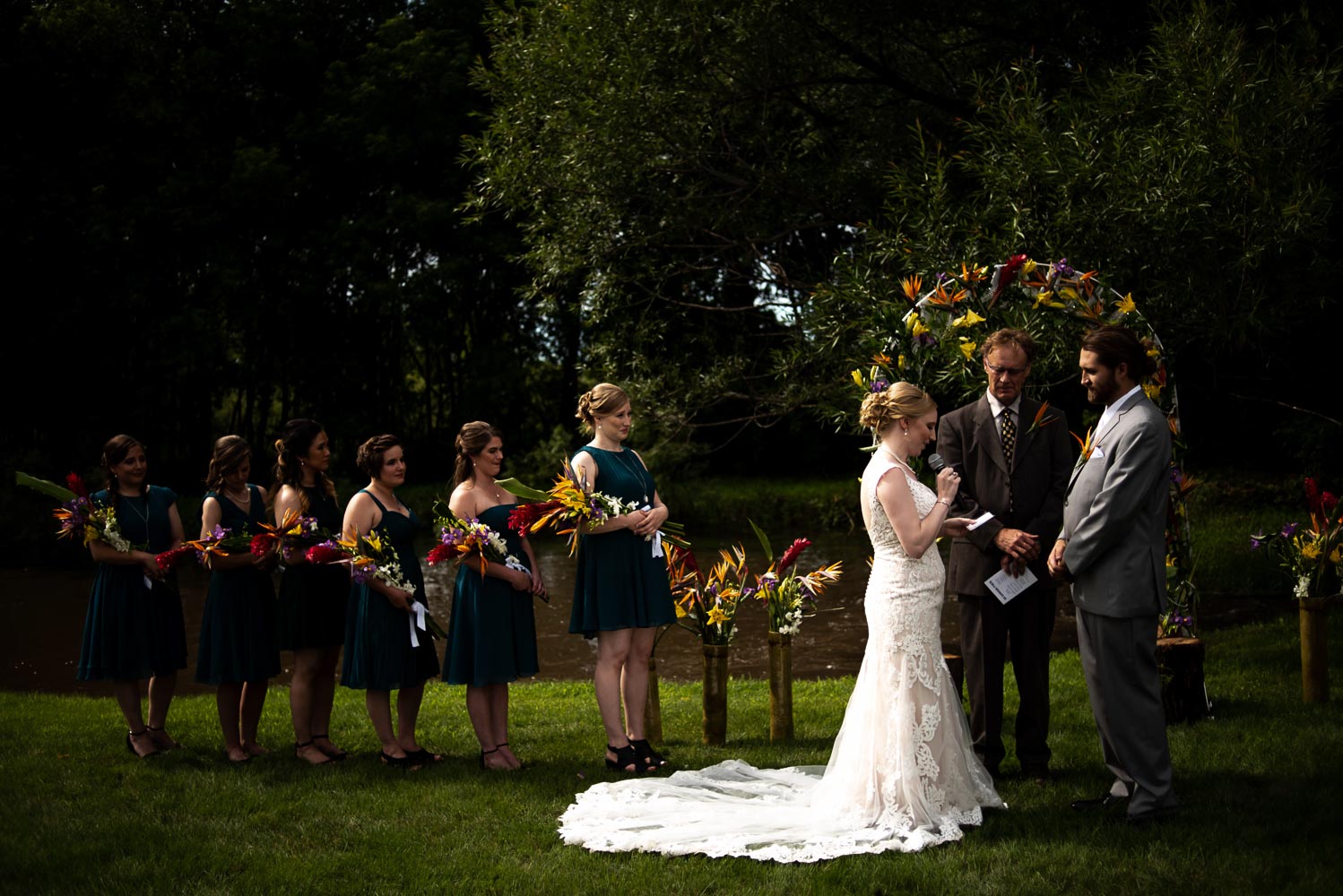 bride and groom standing with their wedding party during their summer wedding ceremony