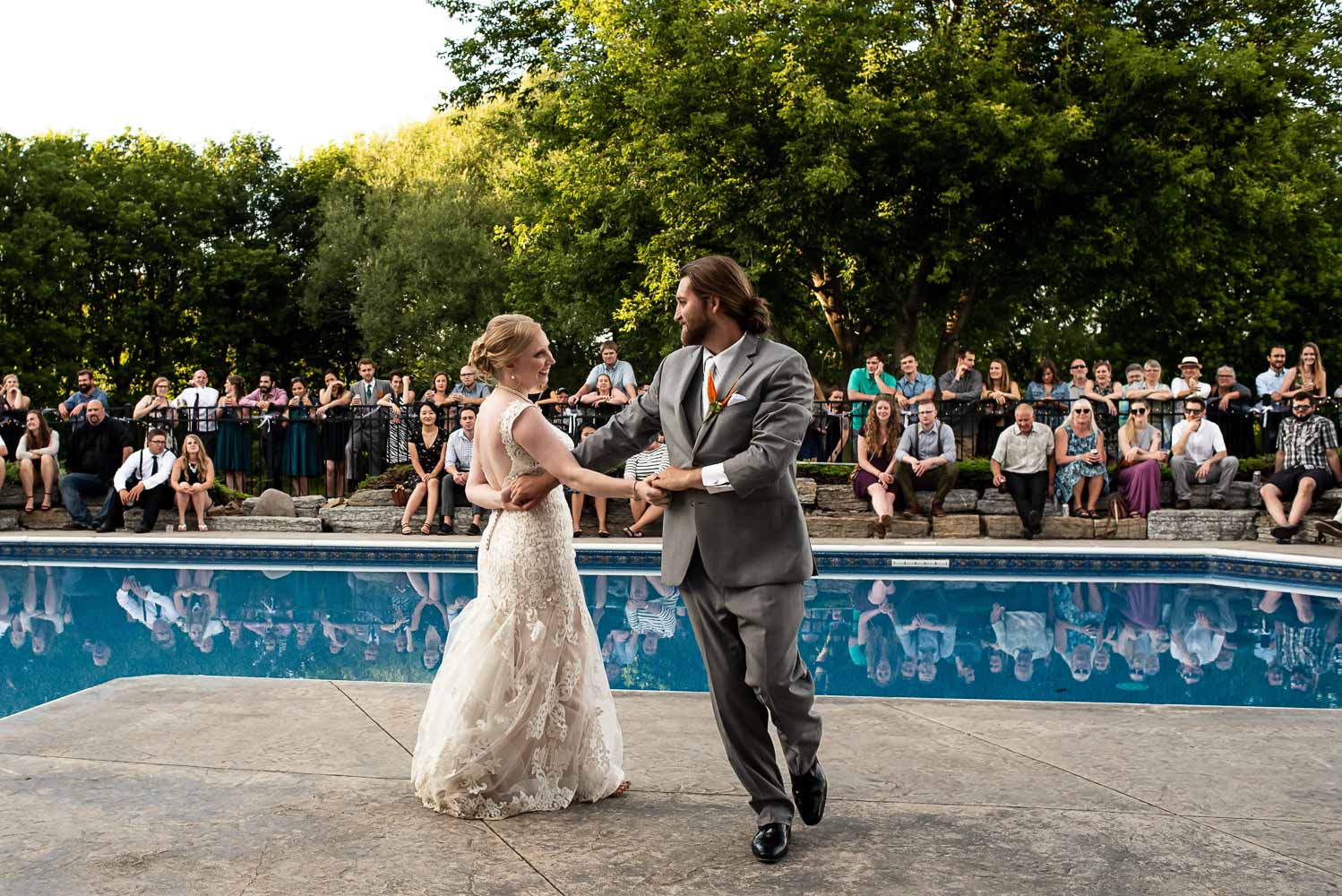 bride and groom first dance by the pool at their backyard summer wedding in Minnesota