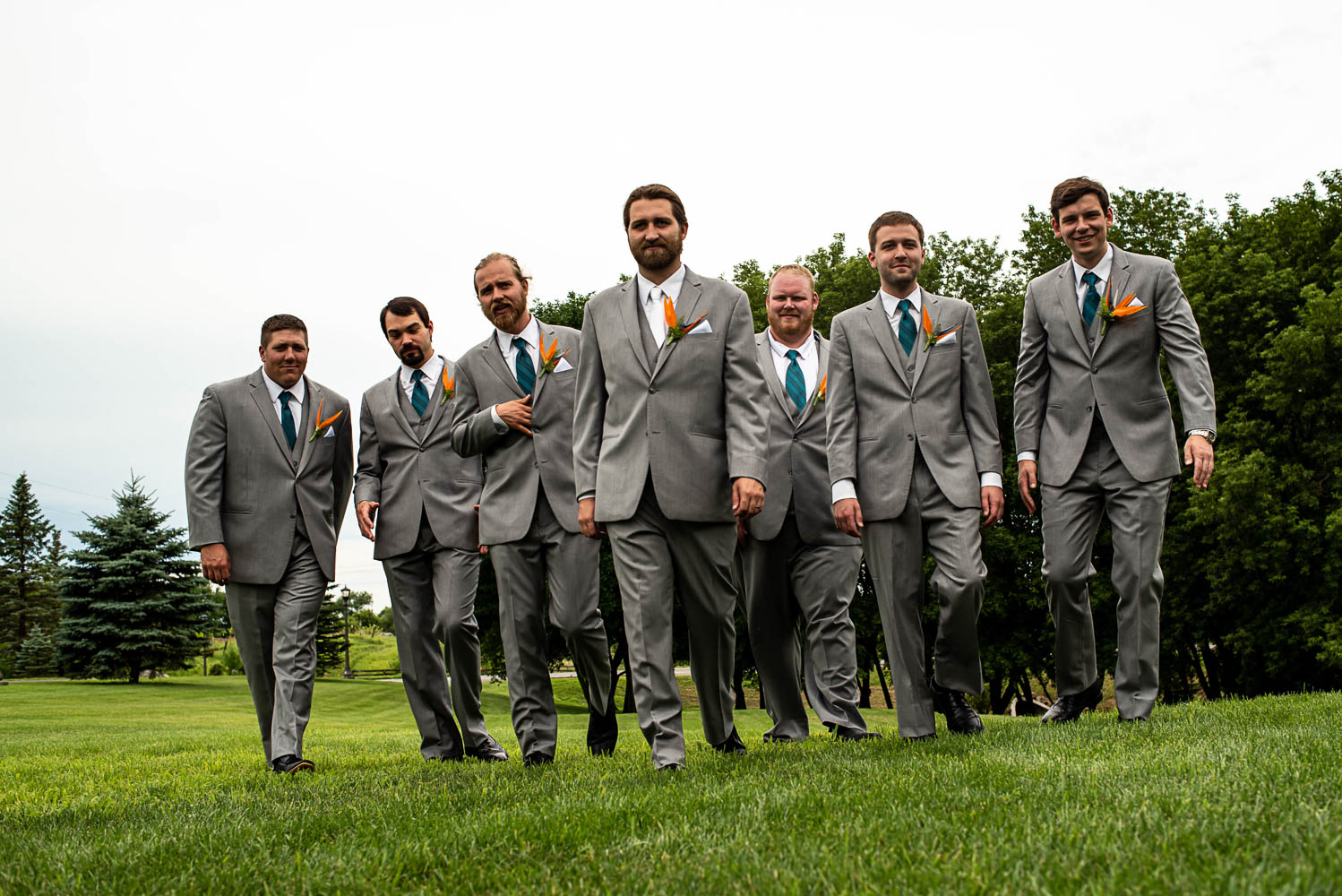 groom and the groomsmen walking together before the Minnesota backyard summer wedding