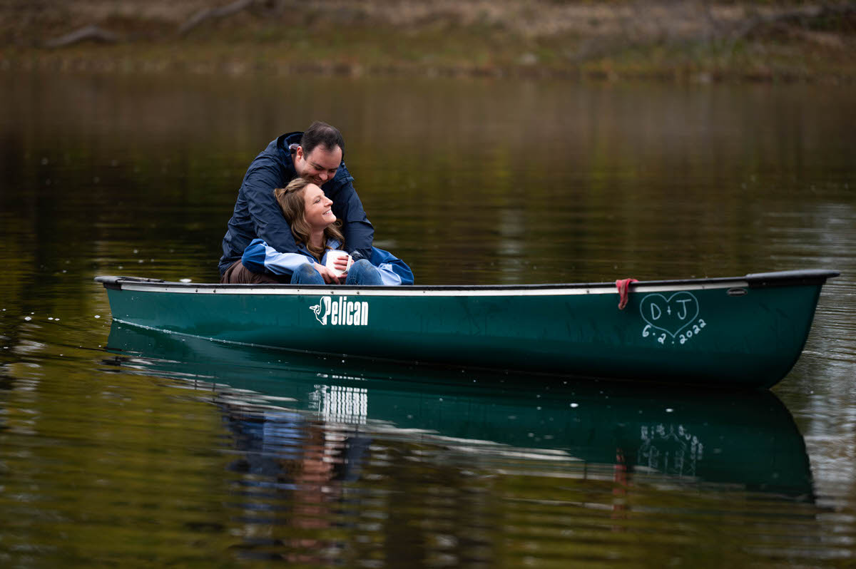 A person leaning back against their partner as they sit in a canoe 