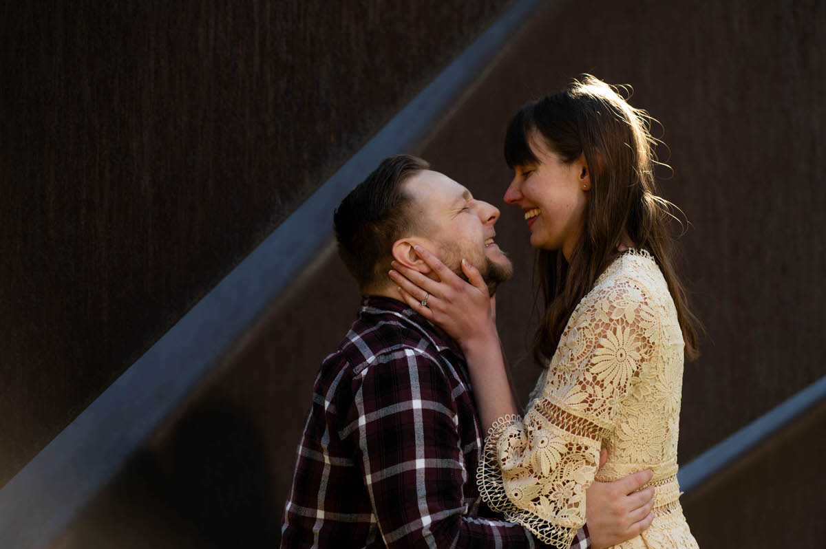 A couple smiling together while one is holding the other's face