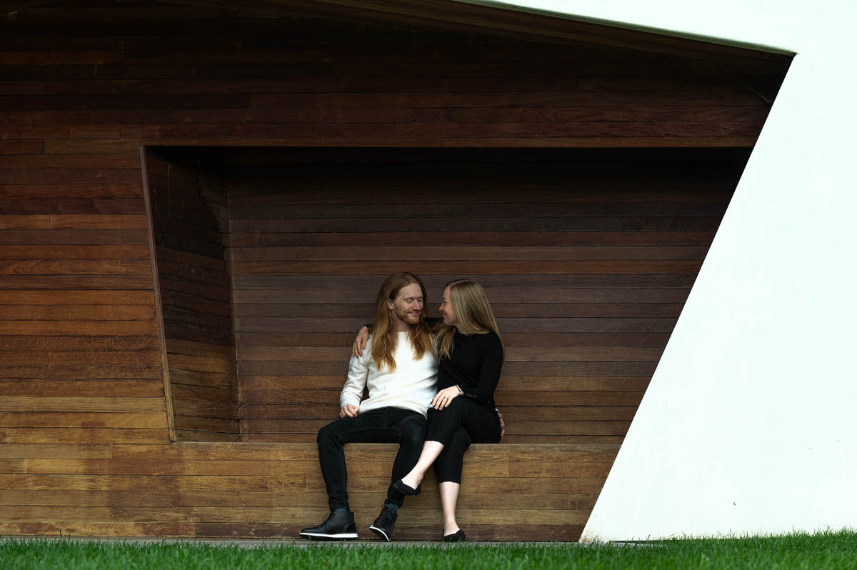 A couple sitting with their arms around each other in a small alcove 