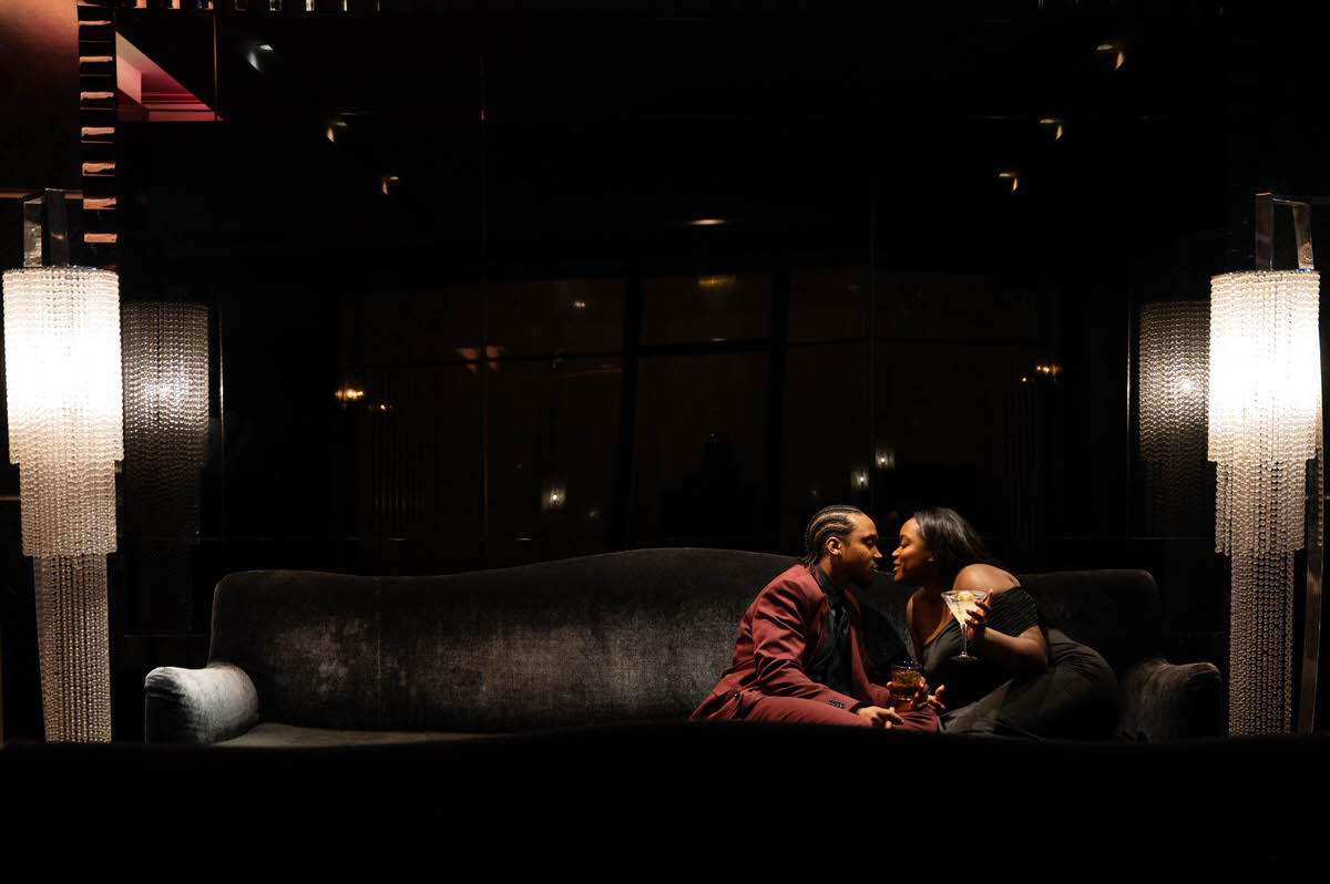 A couple sitting on a couch together as they lean in to kiss