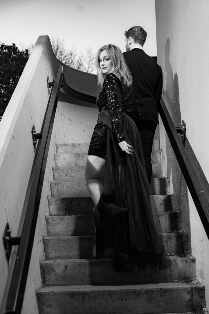 Black and white photo of couple walking up stone steps during St. Anthony Main engagement session.