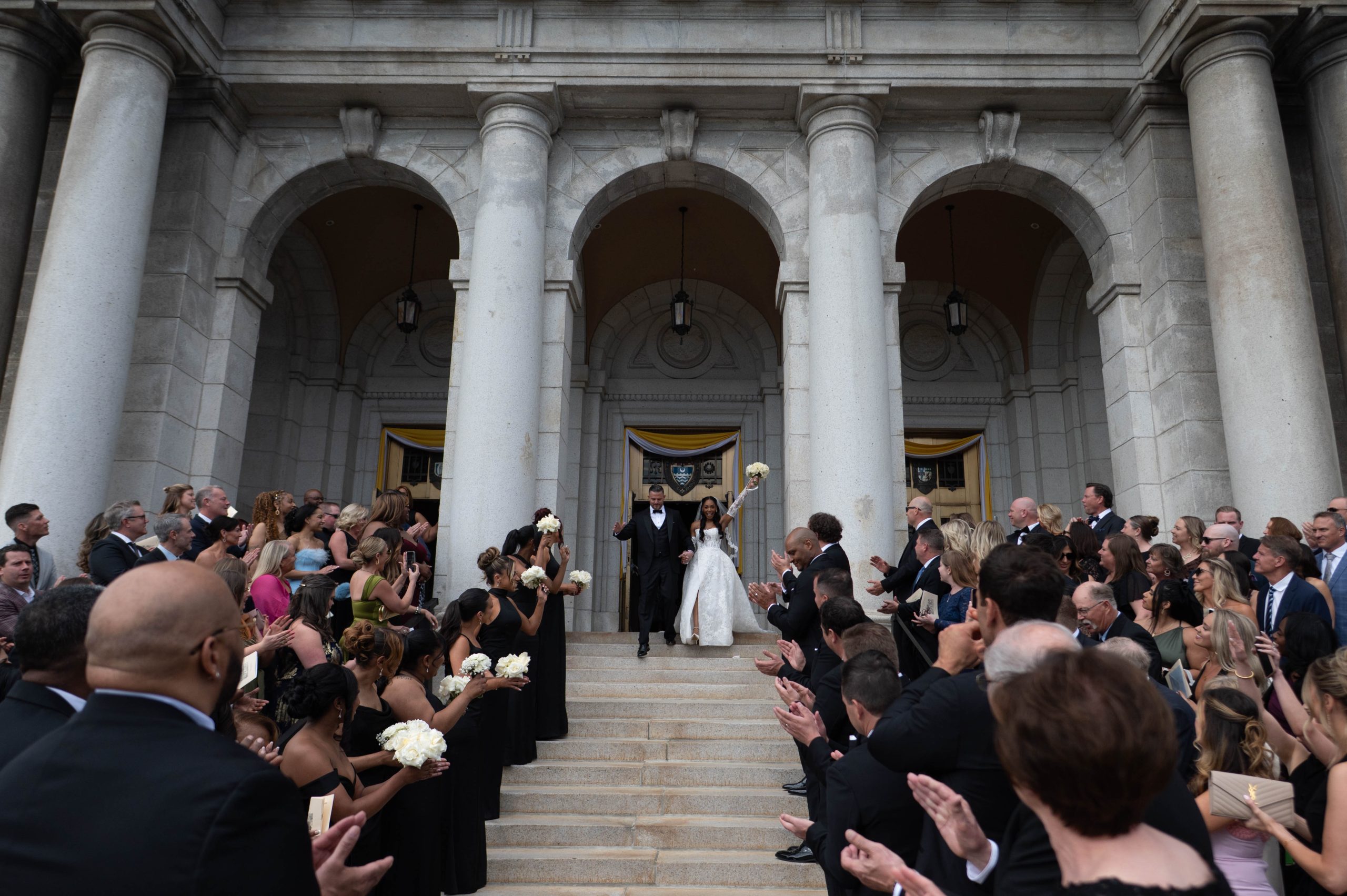 a couple walking down the steps of the Basilica of Saint Mary after their wedding ceremony