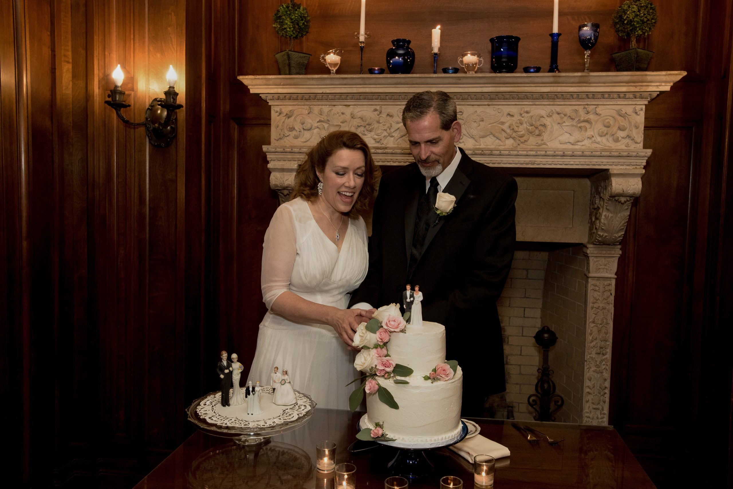 a couple cutting their wedding cake inside of gale mansion on the day of their wedding