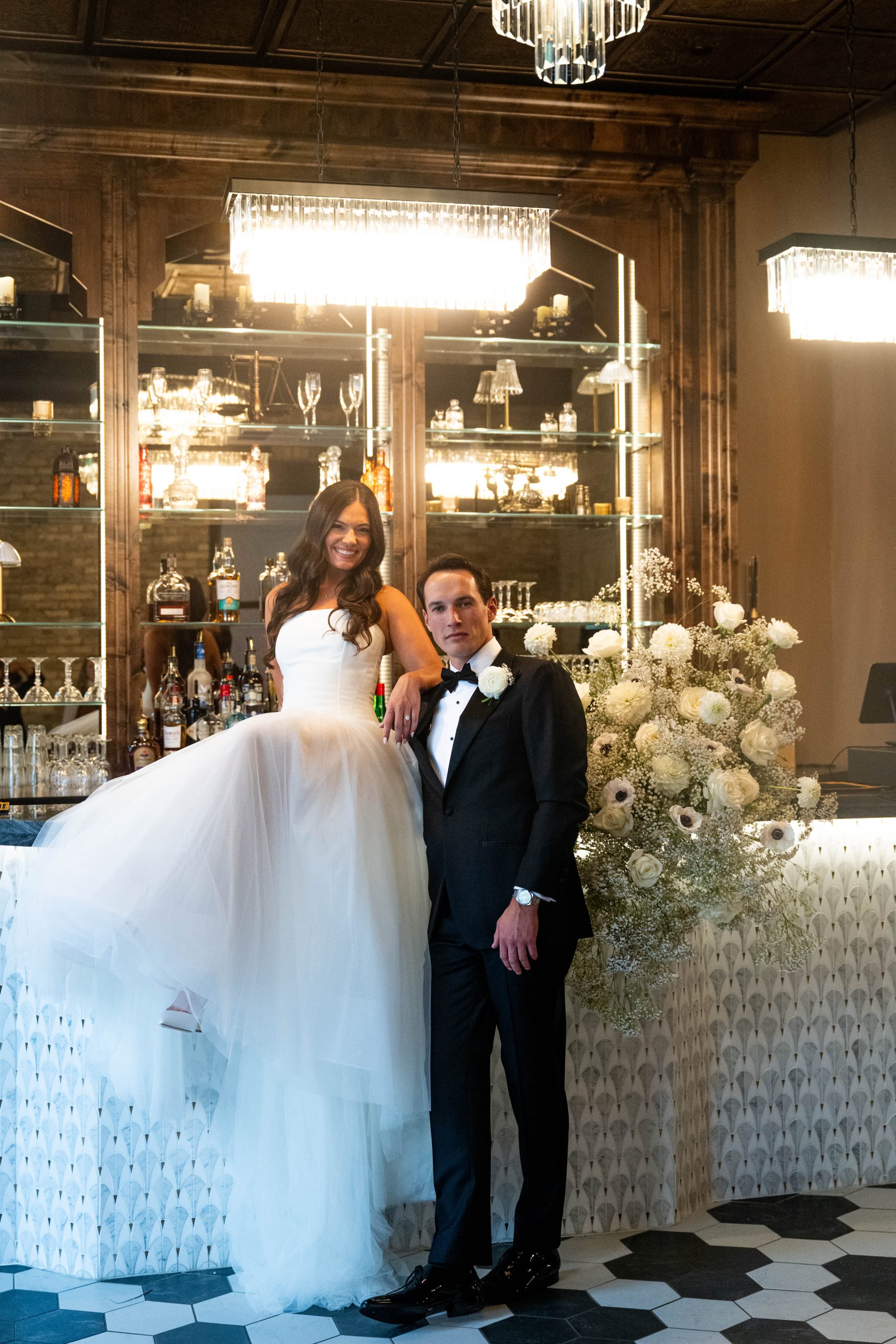 a couple posing in front of the bar in Le VENERÉ taking wedding photos
