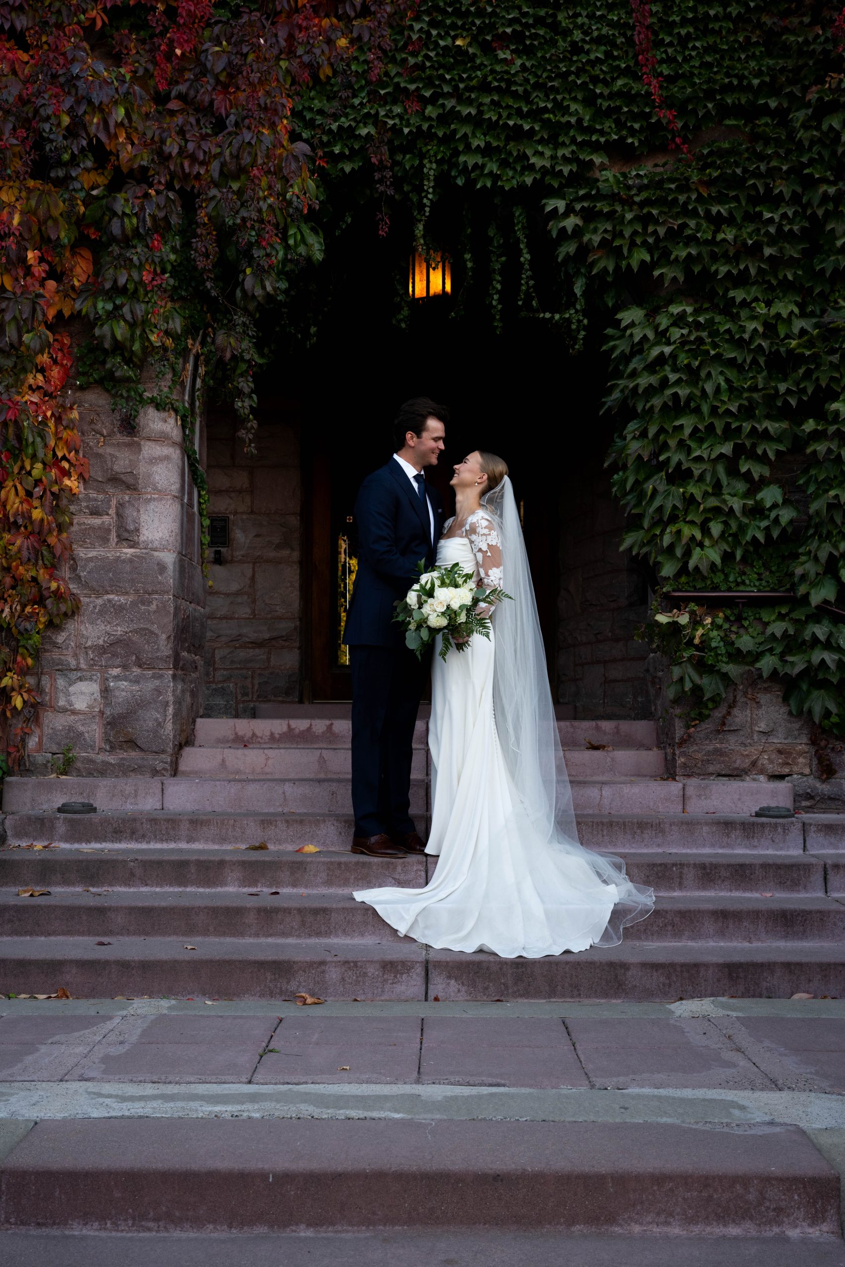 a couple taking wedding photos on the steps at the van dusen mansion