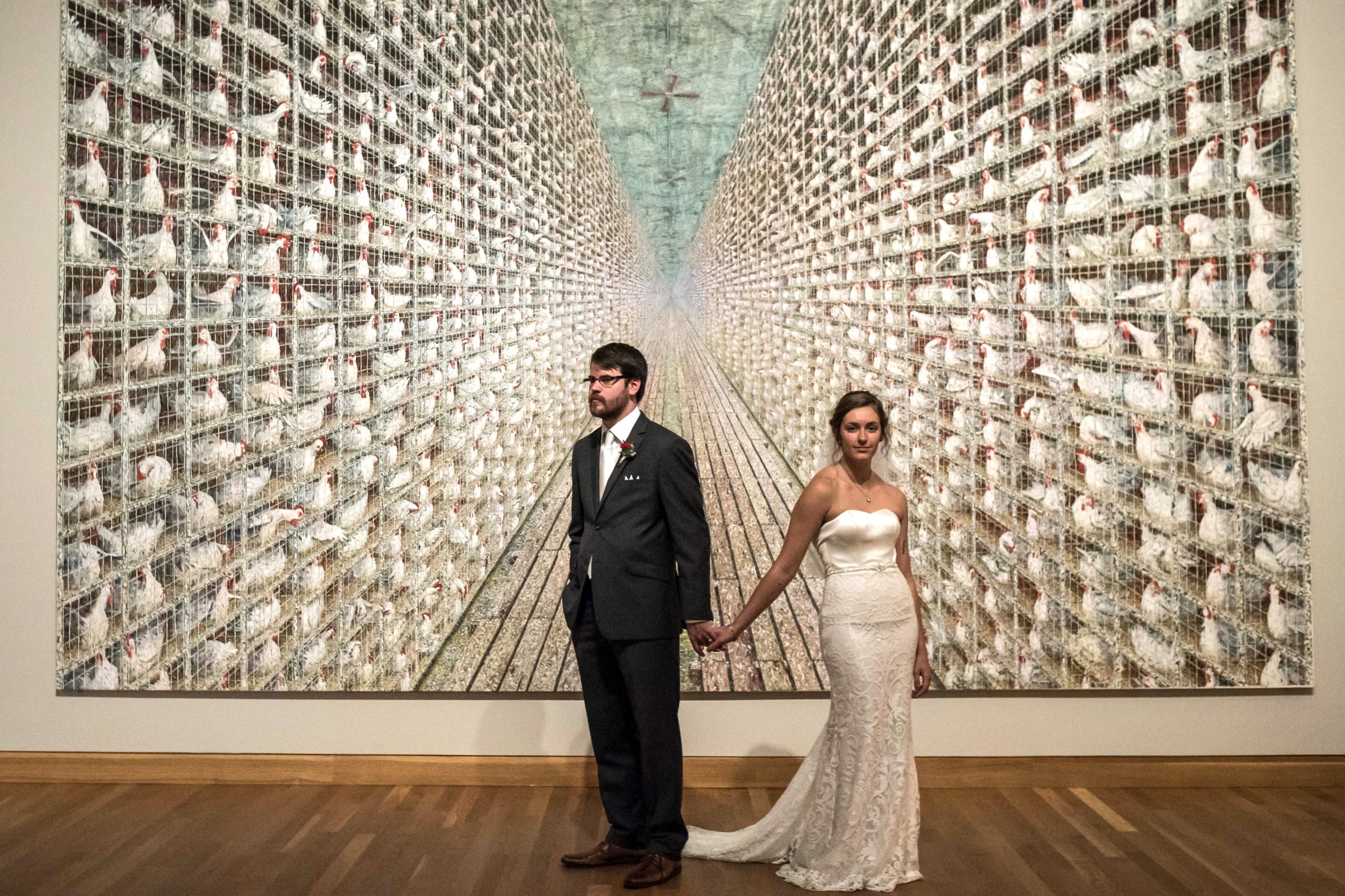 a bride and groom at the Weisman Art Museum taking a wedding portrait in front of a piece of art